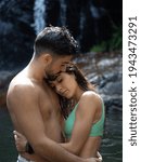 A vertical shot of a couple being affectionate at a river