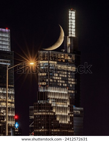 A vertical shot of Crescent moon setting behind Comcast Technology Center in Philadelphia