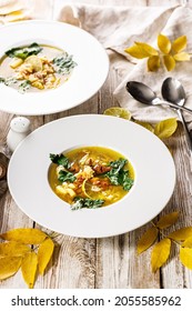 Vertical Shot Delicious Autumn Soup With Chanterelles And Fresh Herbs. Seasonal Dish With Edible Mushrooms. White Plate And Cutlery On A Rustic Background. Food Still Life. Organic Wild Foods.