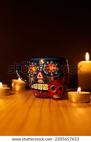 Vertical shot of dia de los muertos or day of the dead mexican sugar skulls with candles on wooden surface with black background