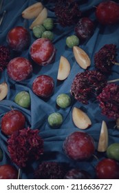 A Vertical Shot Of Different Fruits And Flower On A Blue Table Mat