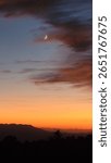 A vertical shot of the dramatic sunset with the moon crescent in Lovell Canyon road, Nevada, USA