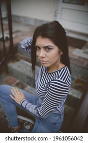 A Vertical Shot Of An Edgy Teenager Sitting On An Apartment Front Steps