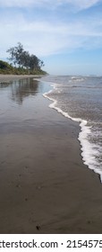 A Vertical Shot Of The Empty Beach With Gentle Ocean Waves 