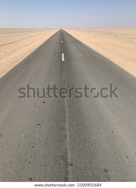 A vertical\
shot of an empty highway in a\
desert