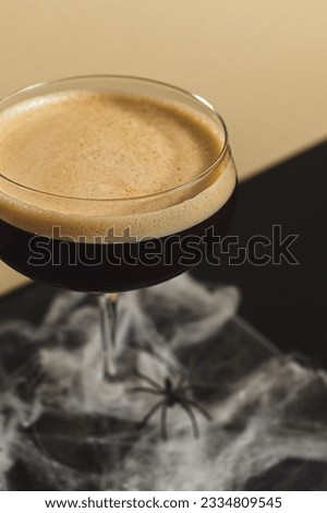 A vertical shot of espresso martini against the Halloween-themed background