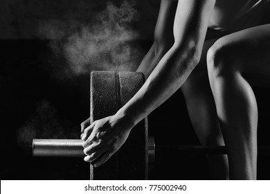 Vertical shot a female crossfit athlete preparing barbell for weightlifting at the gym magnesia protection powerlifting fitness strength athletics workout preparation focusng concentration, crossfit