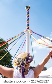 A vertical shot of female in a traditional English hat dancing with a maypole at the Countryfile Live