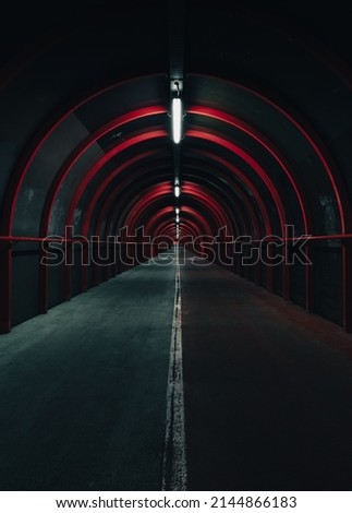 Vertical shot of Glasgow tunnel with red neon lights at night creating a post-apocalyptic mood - Scotland Street Photography Public Transport 