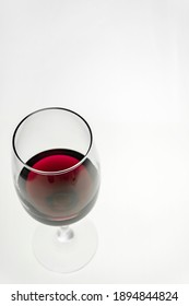 Vertical Shot. A Glass Of Red Wine On A Light Background. 