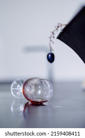 A Vertical Shot Of A Grape And A Spilled Wine On A Table