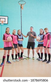 Vertical Shot Of A Gym Teacher And High School Students With Netballs.