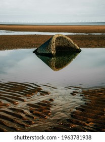 A Vertical Shot Of A Half-submerged Stone On A North Wales Beach