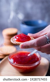 A Vertical Shot Of A Hand Holding Fresh Maria Cookie (galletas Maria) With Strawberry Jam