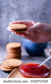 A Vertical Shot Of A Hand Holding Fresh Maria Cookie (galletas Maria) With Strawberry Jam