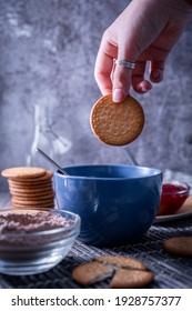 A Vertical Shot Of A Hand Holding A Freshly Bak Maria Cookie (galleta Maria)