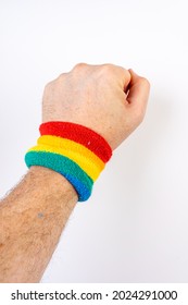 A vertical shot of a hand with a rainbow colored sweatband