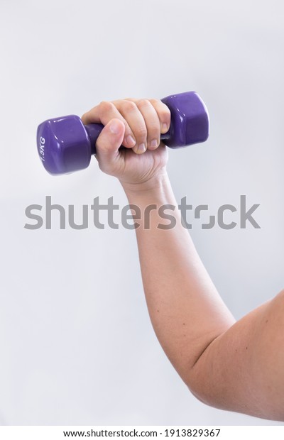 A vertical shot of a hand raising a dumbbell\
on white background