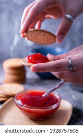 A Vertical Shot Of Hands Making Fresh Maria Cookie (galletas Maria) With Strawberry Jam