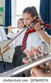 Vertical Shot Of A High School Student Playing Violin During A Music Class.