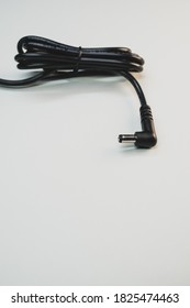 A Vertical Shot Of A Laptop Charger Isolated On A Gray Background