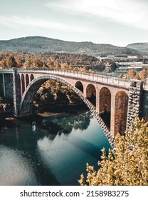 Vertical Shot Of A Large Stone Bridge Passing Through The Big Blue River