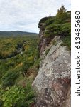 A vertical shot looking down on a river winding through trees on the left and a rock wall on the right.  The Porcupine Mountains in the Upper Peninsula of Michigan.