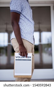 A Vertical Shot Of A Male Holding A Volunteer Sing Up Sheet With A Blurred Background