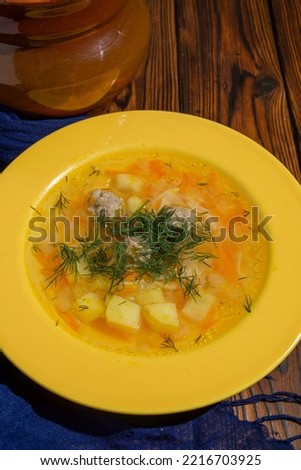 Vertical shot of  meatball soup and brown clay pot on dark roustic table background