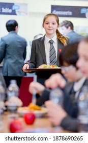 Vertical Shot Of A Middle School Student Carrying Lunch Tray In The School Cafeteria.