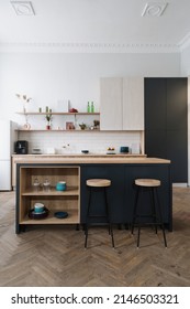 Vertical Shot Of Modern Kitchen With Luxury Furniture, Wooden Cabinets, Countertop And Household Equipment. Bar Chairs Near Dining Table In Apartment With Loft Style Interior Design