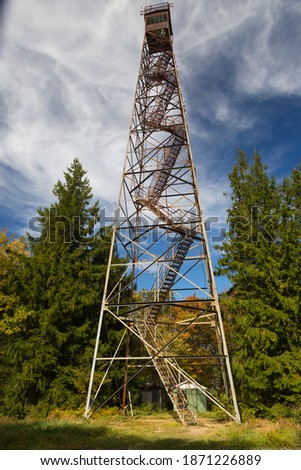 A vertical shot of the Olson Tower surrounded by greenery under a cloudy sky in West Virginia