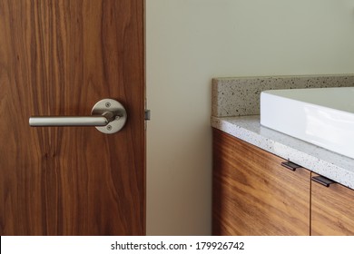 Vertical Shot Of A Open Wooden Bathroom Door With A Modern Handle/Luxury Bathroom With Open Wooden Door