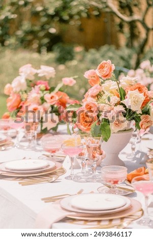 A vertical shot of an outdoor wedding table with flowers and elegant tableware