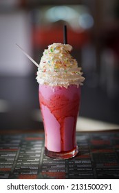 A Vertical Shot Of A Pink Milkshake With Whipped Cream