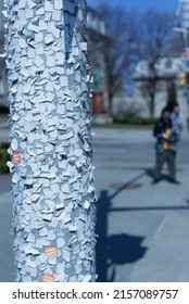 A vertical shot of a post plastered with ads