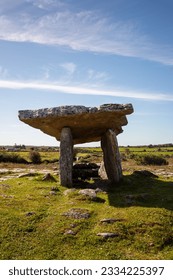A vertical shot of Poulnabrone Dolmen in a green field in the Burren, County Clare, Ireland