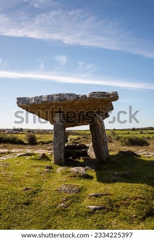A vertical shot of Poulnabrone Dolmen in a green field in the Burren, County Clare, Ireland