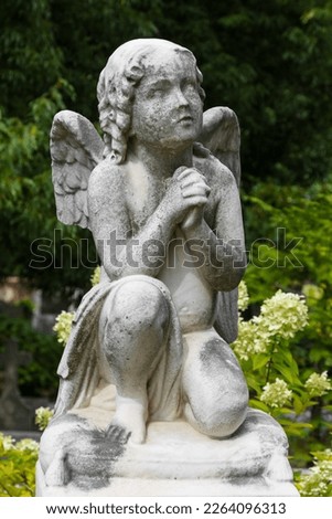 Vertical shot of praying cherub angel in a cemetery in Atlanta