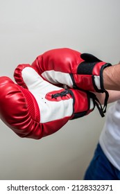 A Vertical Shot Of Red Sparring Gloves On Boxer's Hands On A White Background