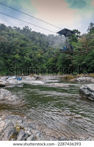 Vertical shot of a river with calm water with rafting rafts in one in the middle of the jungle on the Pacuare River in Costa Rica with a cargo stroller