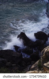 A Vertical Shot Of A Rogue Waves Crashing Into Cliffs