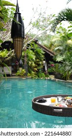 A Vertical Shot Of A Round Tray With Food And Drinks In The Pool Floating On The Water's Surface 