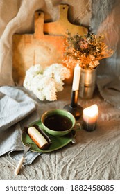 A vertical shot of a rustic breakfast setting with a cup of tea and eclair