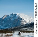 A vertical shot of the snowy Dalton Highway in Alaska during dayligh