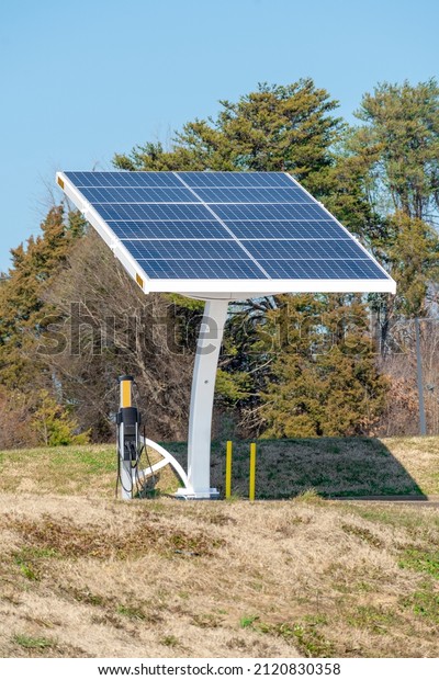 Vertical shot of a solar engery\
panel array connected to an electrical vehicle charging\
station.