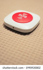 A vertical shot of an SOS button on a cream surface