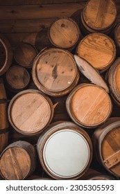 A vertical shot of stack of old wine barrels in the wooden basement