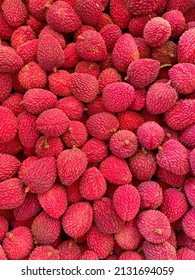 A vertical shot of a stack of pink and organic Lychee fruits