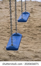 A Vertical Shot Of A Swing Set Above The Sand-covered Ground